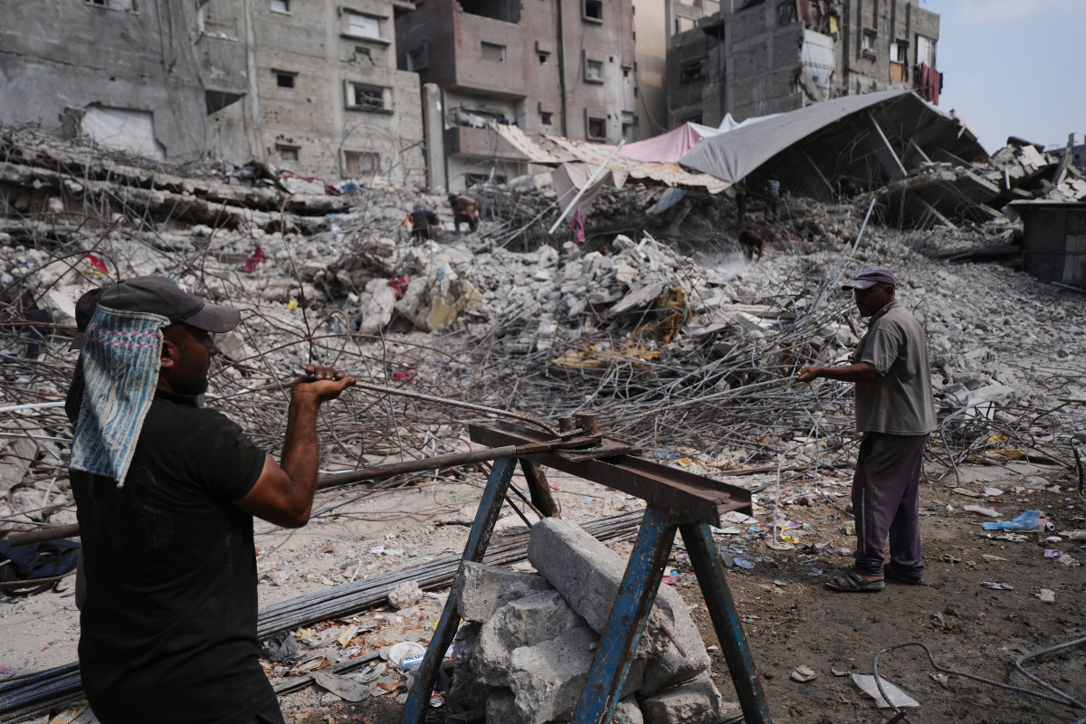 Palestinians remove iron from the rubble of buildings destroyed by Israeli airstrikes during the war with Hamas, repair and recycle it for construction, building tents or selling it, in Gaza City, Sunday, Aug. 16, 2026.