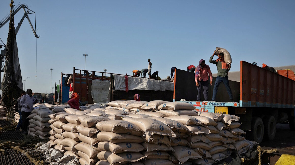 FILE PHOTO: Workers unload sacks of sugar from trucks and place them in a net to be loaded onto a cargo ship at the Deendayal Port in Kandla, in the western state of Gujarat, India, April 5, 2025.