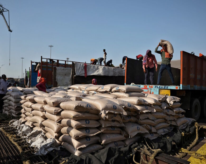 FILE PHOTO: Workers unload sacks of sugar from trucks and place them in a net to be loaded onto a cargo ship at the Deendayal Port in Kandla, in the western state of Gujarat, India, April 5, 2025.