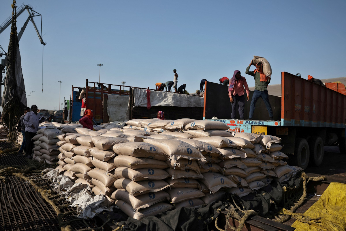 FILE PHOTO: Workers unload sacks of sugar from trucks and place them in a net to be loaded onto a cargo ship at the Deendayal Port in Kandla, in the western state of Gujarat, India, April 5, 2025.