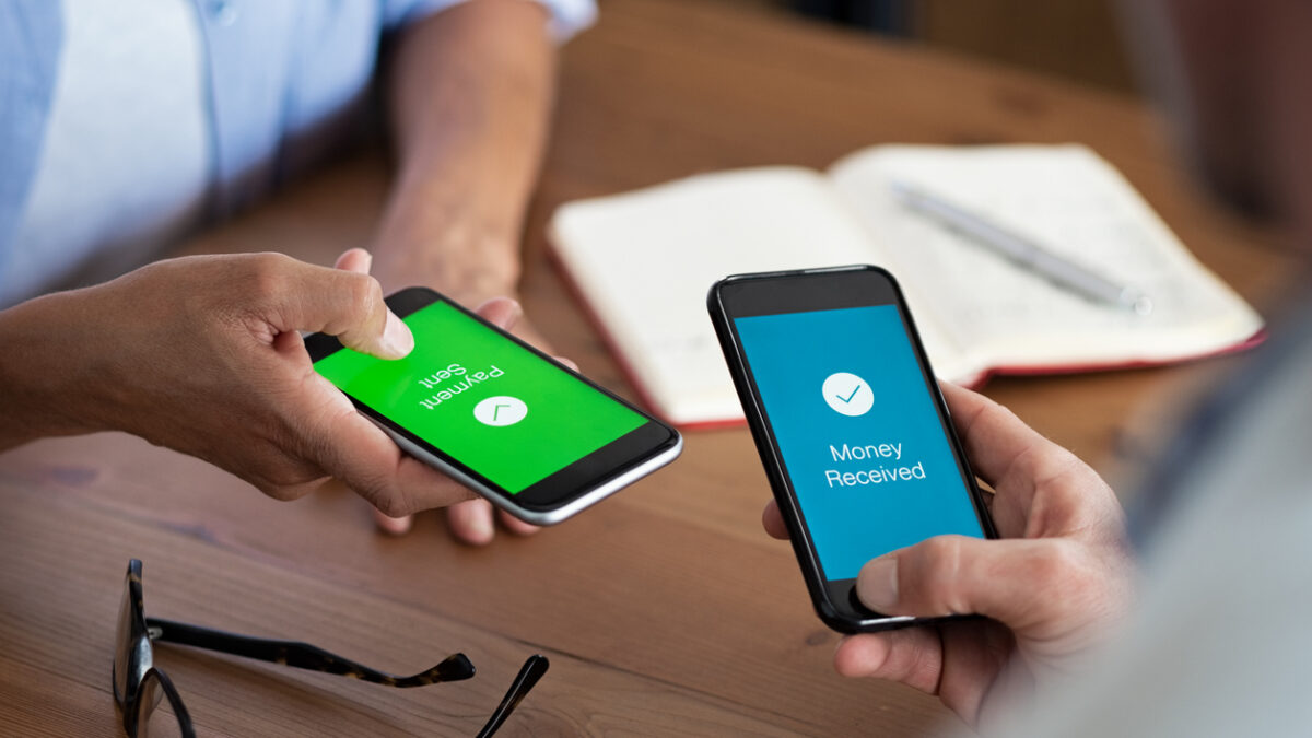 Closeup hands holding mobile phone with application for send and receive money. Man and woman holding smartphone and making payment transaction. Smart phone screen displaying payment sent and money received message after transaction.