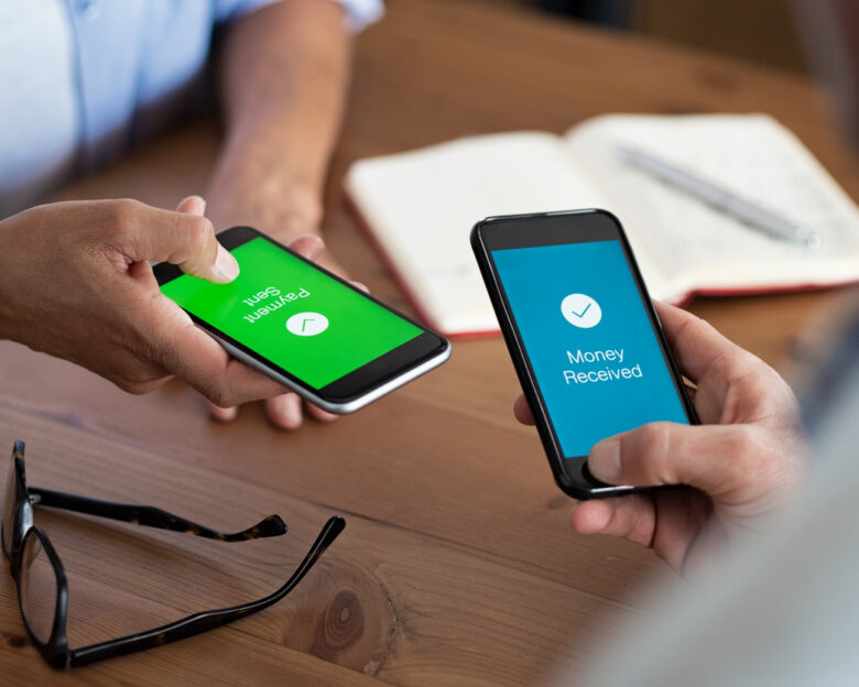 Closeup hands holding mobile phone with application for send and receive money. Man and woman holding smartphone and making payment transaction. Smart phone screen displaying payment sent and money received message after transaction.