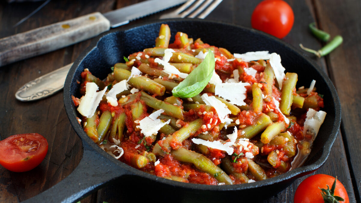 French beans with tomato stew top view on a dark table