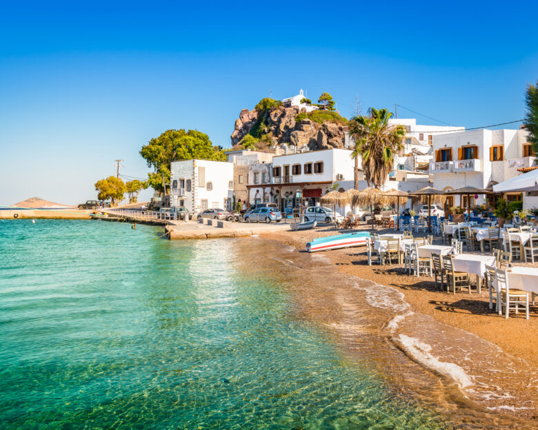 Bright and colorful horizontal image of Skala town. Clear blue sky and small beach close to the harbor of Patmos, Greece.
