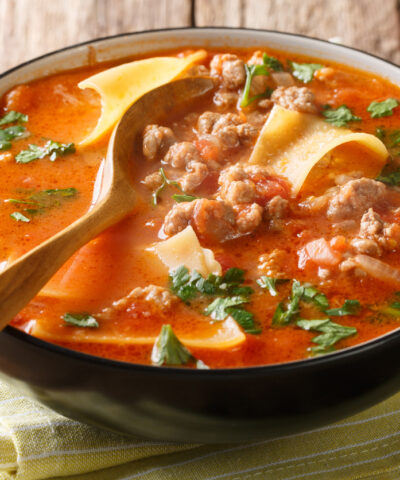 Portion of rich lasagna soup close-up in a plate on the table. horizontal