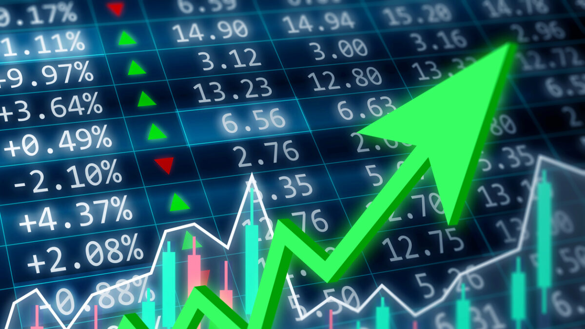 Stock market, financial and business concept. Financial data on a monitor with green arrow going up and red, green candle stick graph chart on dark background