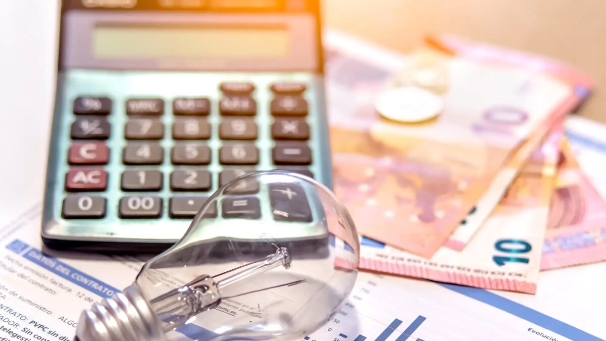Electricity bill next to a calculator, a bulb and money. Electricity price concept.