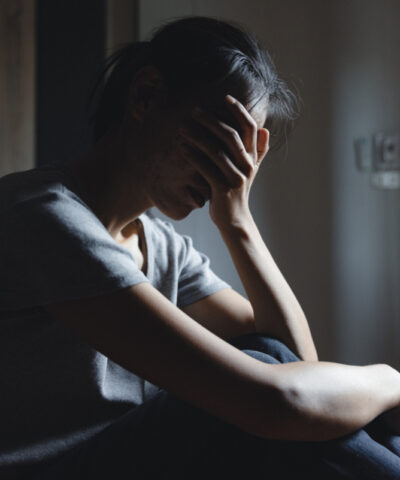 Sad woman sitting alone, woman on the bed, stress, suicidal thoughts, human trafficking