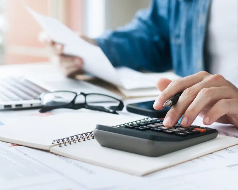 Investors are calculating profits and costs with calculators, growth and investment chart analysis, business planning and strategies to maximize sales profits. Long term business plan.