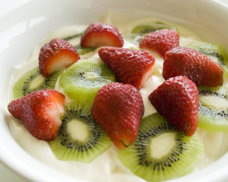 large bowl of yoghurt with sliced fresh fruit on top