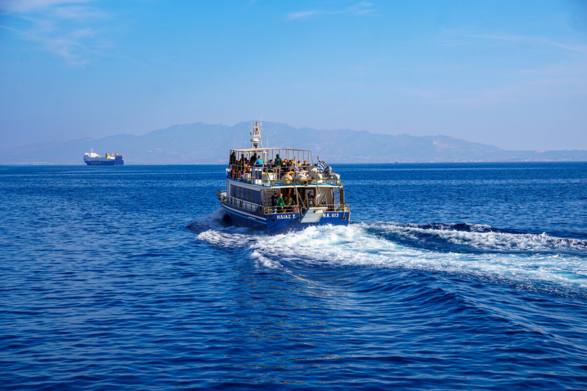 Pothia, Kalymnos, Greece, October 27,2024. Fully occupied passenger ship on the way from Kalymnos to Kos, Greece. In the background a ferry.