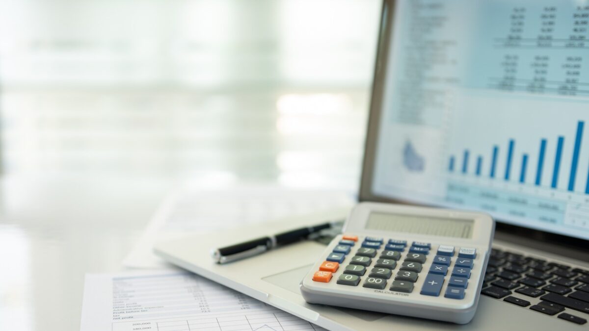 calculator, account statement and business report with financial budget portfolio show on screen laptop computer. accounting business concept.