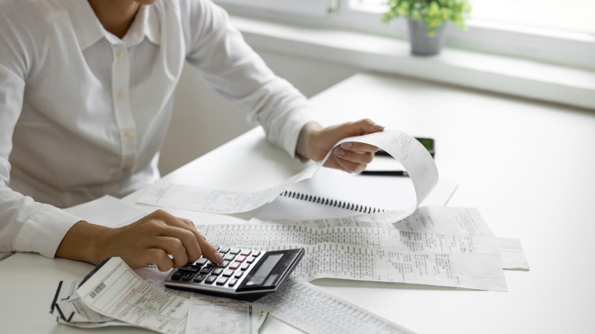 Businesswoman calculating monthly bills with calculator