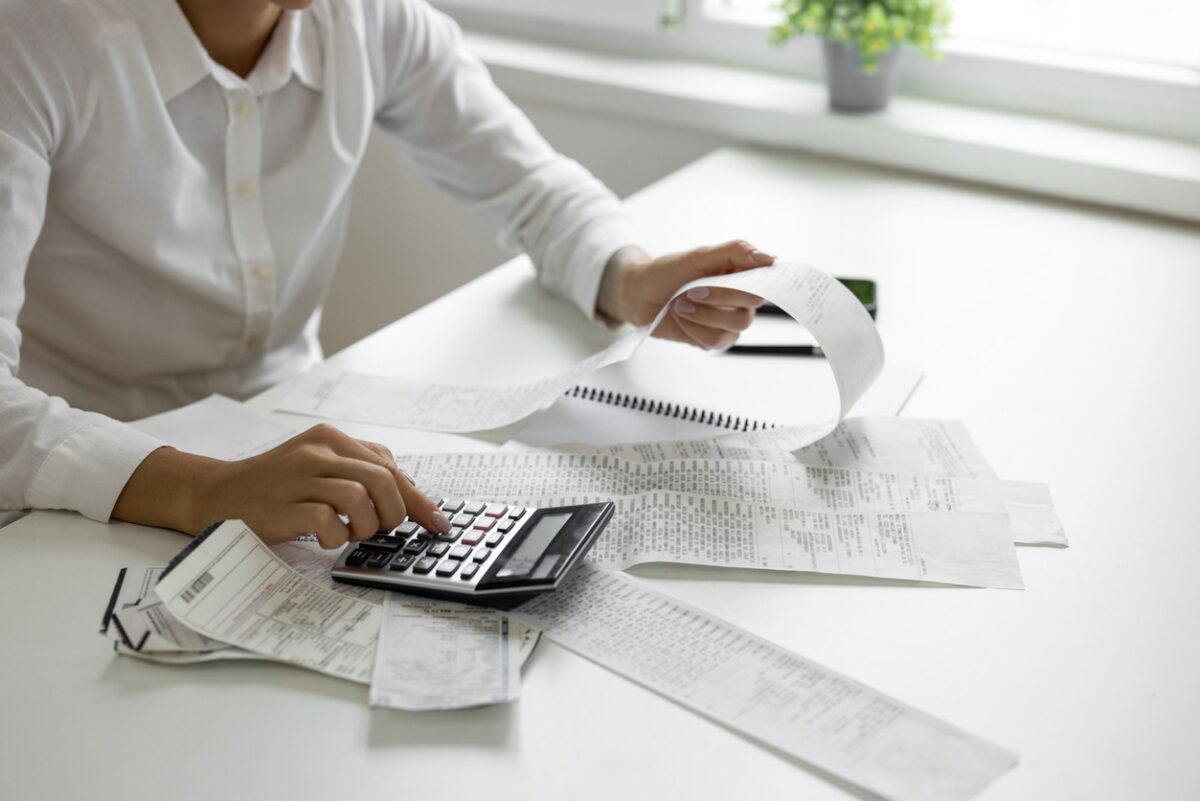 Businesswoman calculating monthly bills with calculator
