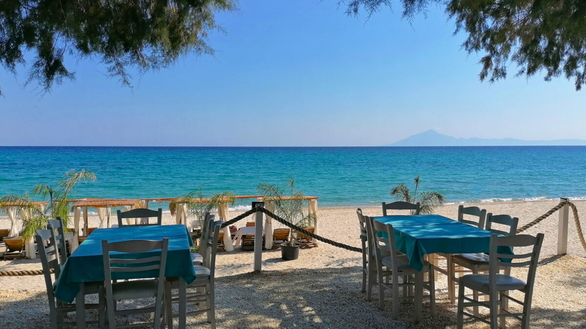 Tables and chairs on the beach of Thassos, Greece. Beautiful beach in Limenaria resort photo images