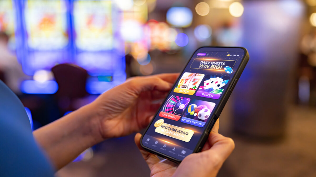 Close-up on a player gambling online at the casino using a mobile app on her cell phone