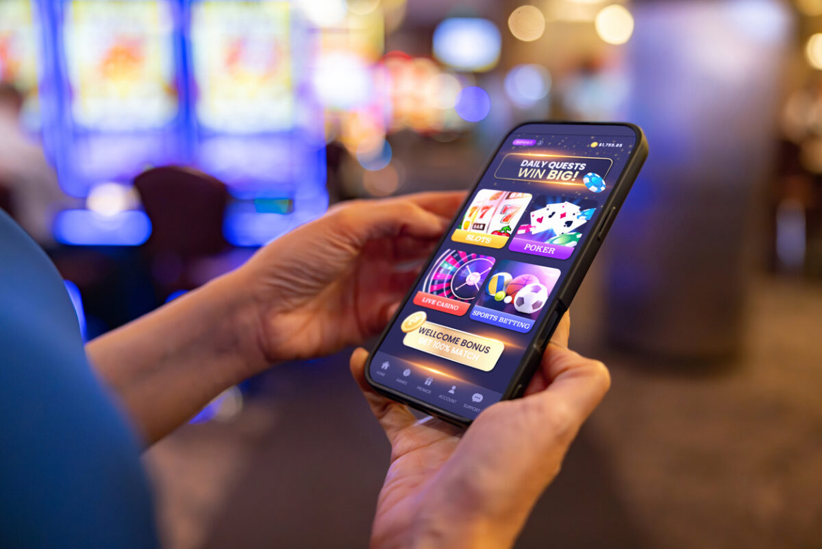 Close-up on a player gambling online at the casino using a mobile app on her cell phone