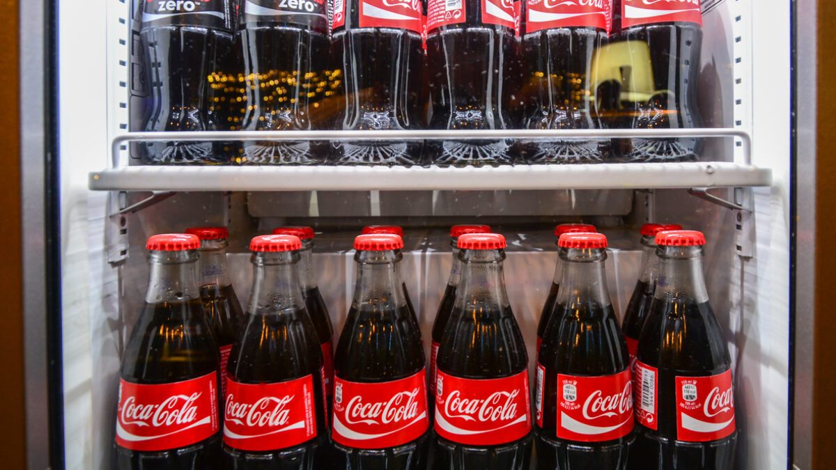 Glass bottles of famous coca-cola drink in the fridge. Picture was taken in Alloro, one of the restaurants in Subotica, Serbia. Photographed through fridge window.