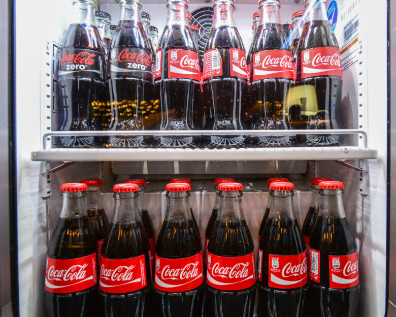 Glass bottles of famous coca-cola drink in the fridge. Picture was taken in Alloro, one of the restaurants in Subotica, Serbia. Photographed through fridge window.