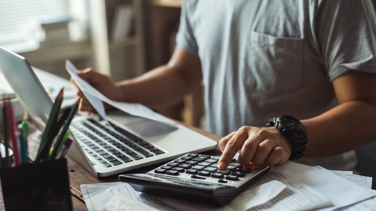 Men is calculating the cost of the bill. She is pressing the calculator.