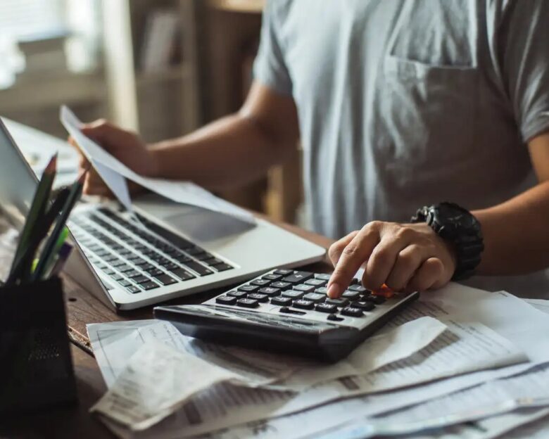 Men is calculating the cost of the bill. She is pressing the calculator.
