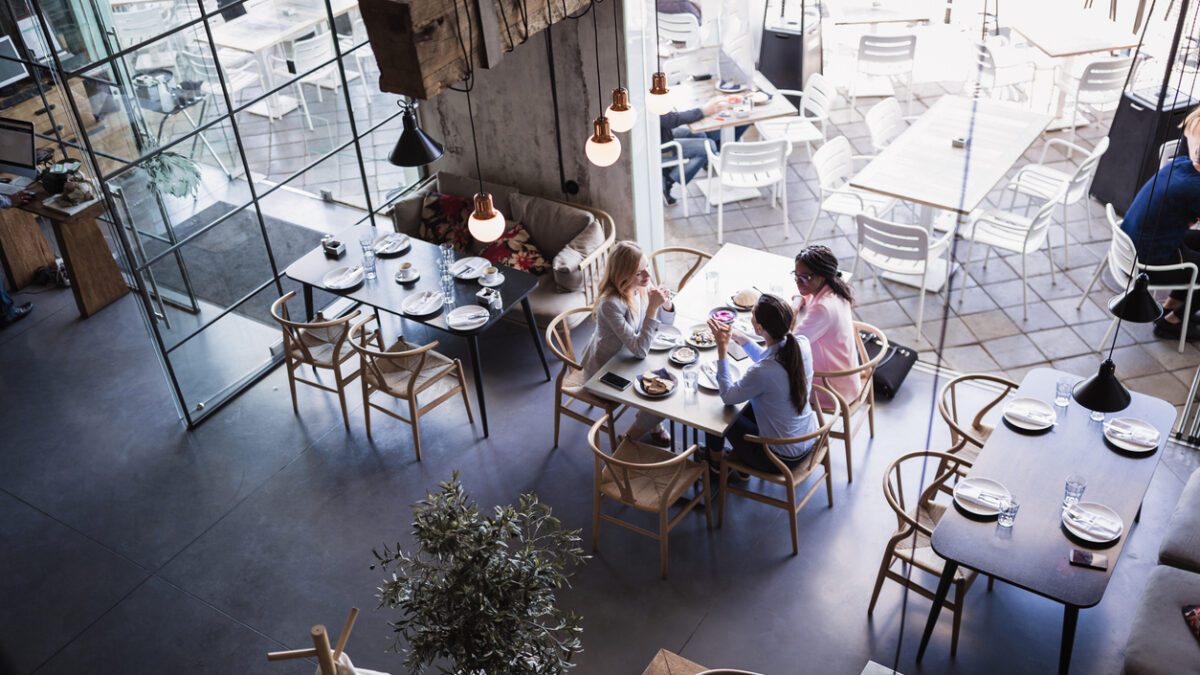 Three businesswomen having meeting and business lunch at high-end restaurant