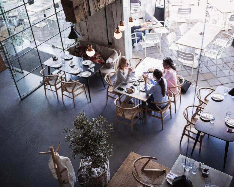 Three businesswomen having meeting and business lunch at high-end restaurant