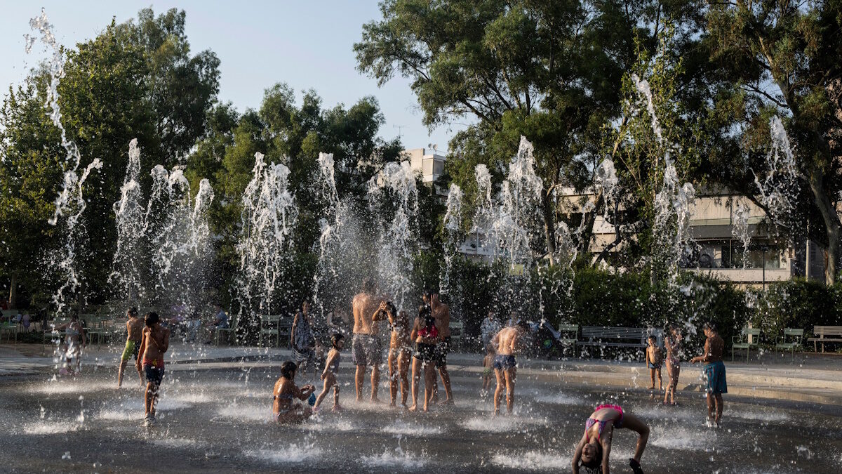 Παιδιά παίζουν με το νερό σε ένα σιντριβάνι κατά τη διάρκεια ενός καύσωνα, στο Πολιτιστικό Κέντρο του Ιδρύματος Σταύρος Νιάρχος στην Αθήνα