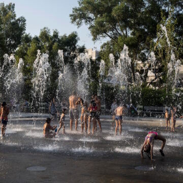Παιδιά παίζουν με το νερό σε ένα σιντριβάνι κατά τη διάρκεια ενός καύσωνα, στο Πολιτιστικό Κέντρο του Ιδρύματος Σταύρος Νιάρχος στην Αθήνα