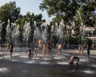 Παιδιά παίζουν με το νερό σε ένα σιντριβάνι κατά τη διάρκεια ενός καύσωνα, στο Πολιτιστικό Κέντρο του Ιδρύματος Σταύρος Νιάρχος στην Αθήνα
