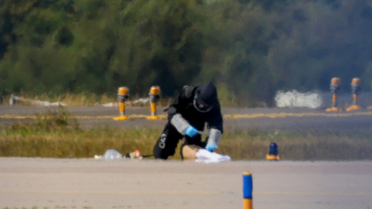 A police officer in protective clothing works at Leipzig/Halle Airport in Schkeuditz, Germany, August 5, 2026, after the police said explosives experts examined a drone near a runway, and after a DHL cargo aircraft hit an unknown object as it was climbing away from the airport overnight, prompting an unscheduled landing in Hanover, according to a source familiar with the incident. REUTERS/Axel Schmidt TPX IMAGES OF THE DAY