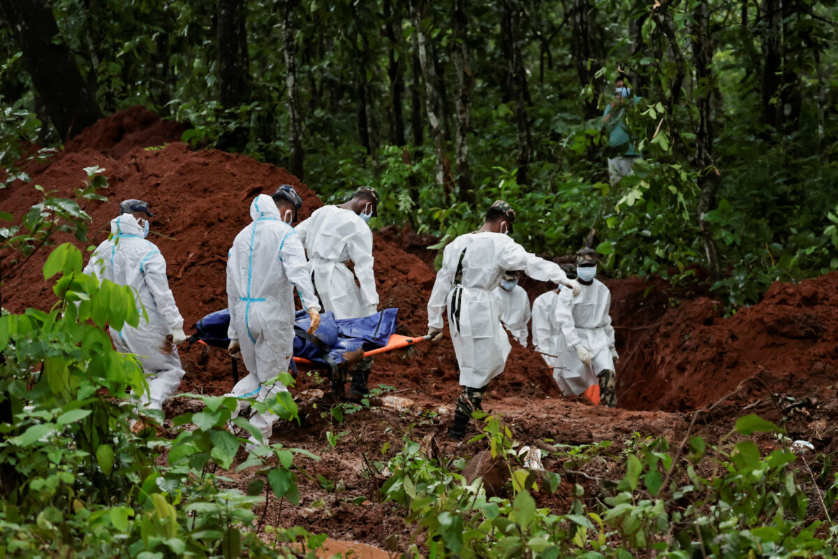 Armed Police Force (APF) officers work on transporting bodies to the pit at Devghat mass burial site for victims of deadly flash floods and mudslides in Chitwan, Nepal, August 30, 2026. REUTERS