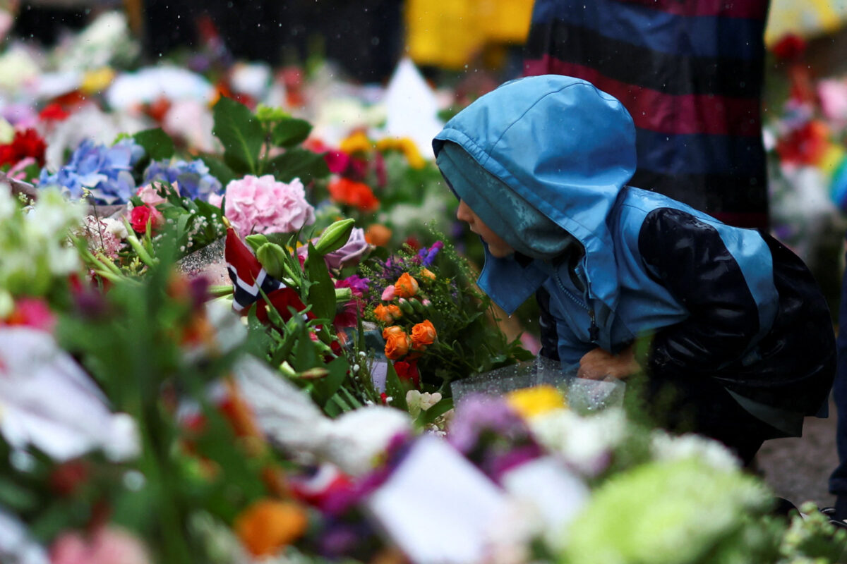 A child next to floral tributes placed outside the Royal Palace, following the death of Norway's King Harald in Oslo, Norway, August 29, 2026. REUTERS