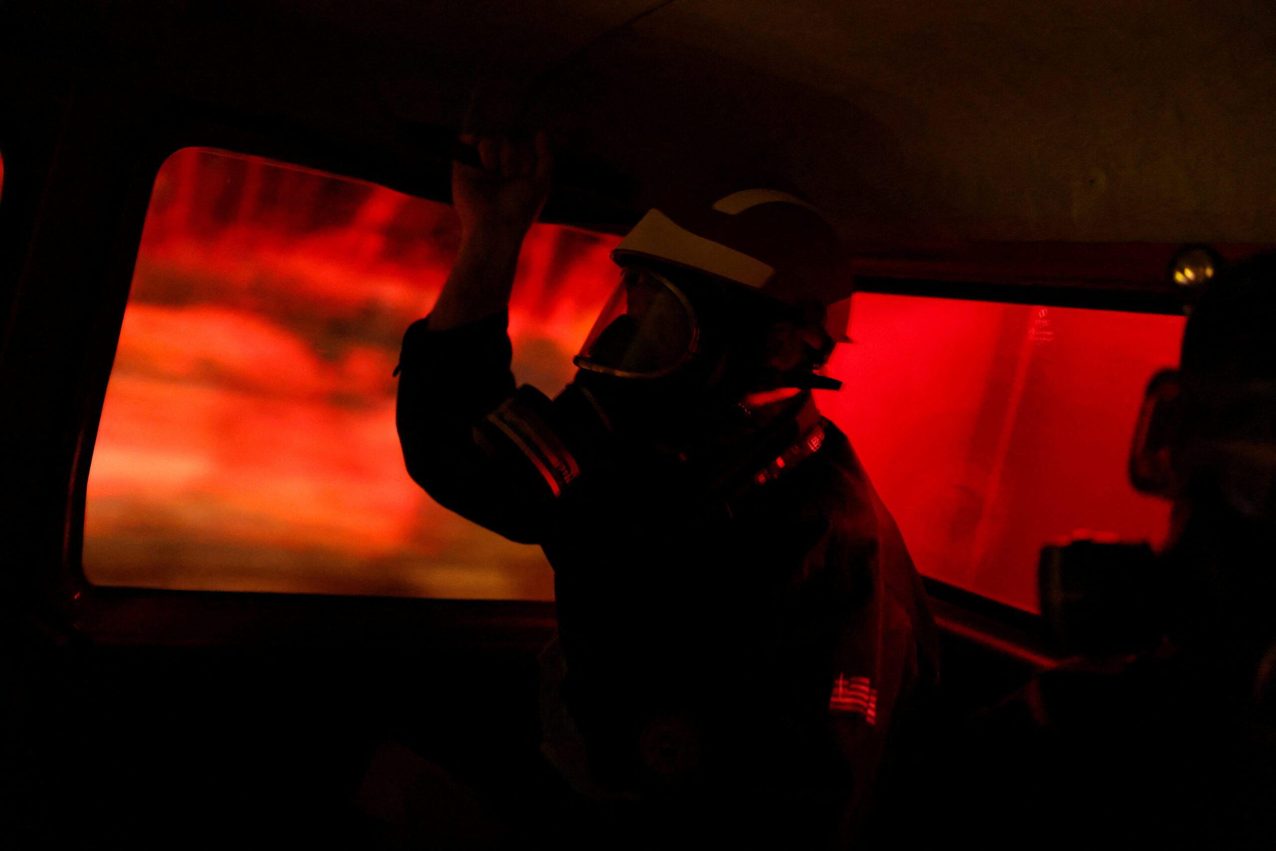Wildfire burns near Agia Paraskevi A volunteer firefighter is silhouetted inside a fire truck as a wildfire burns near the village of Agia Paraskevi, Greece, August 2, 2026. REUTERS/Stelios Misinas