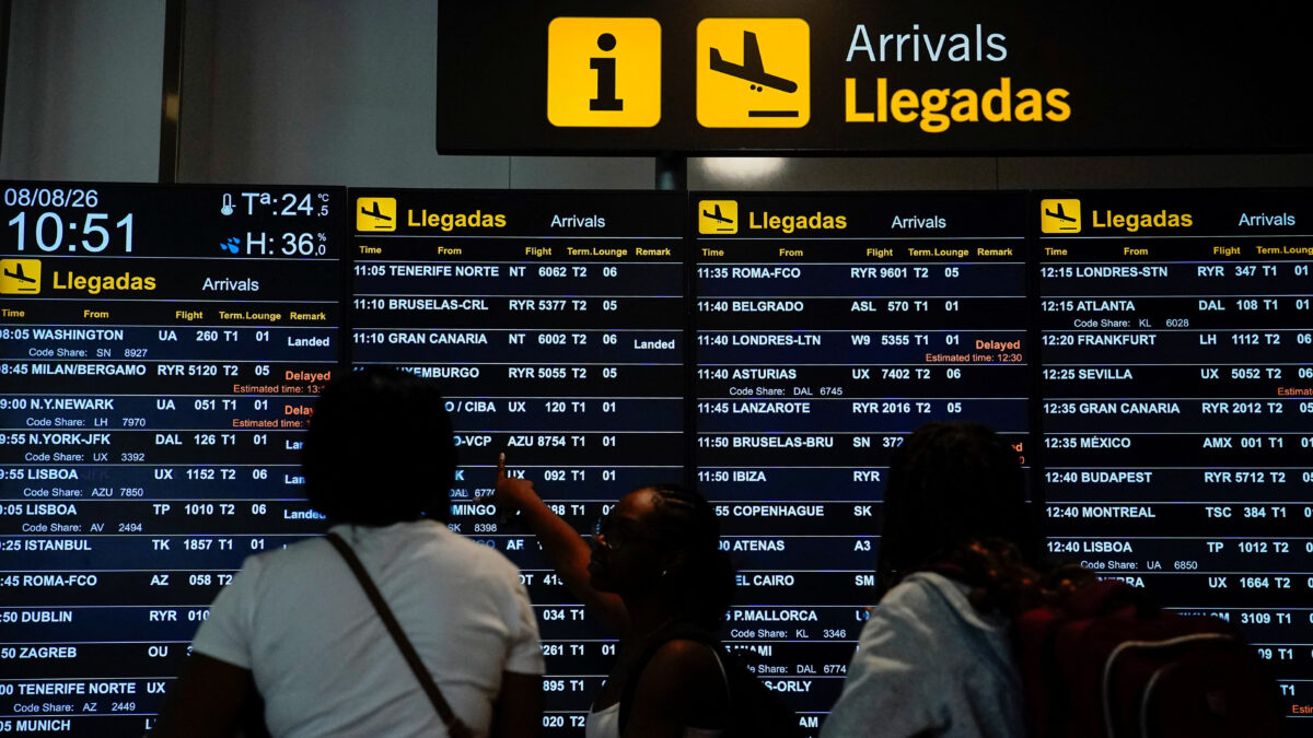 People look at an information panel displaying flight details at Adolfo Suarez Madrid–Barajas Airport, as Spain's government said it would establish border controls for flights and ships from Italy, from midnight on Saturday until September 7, in a dispute over irregular migration, in Madrid, Spain August 8, 2026. REUTERS/Ana Beltran