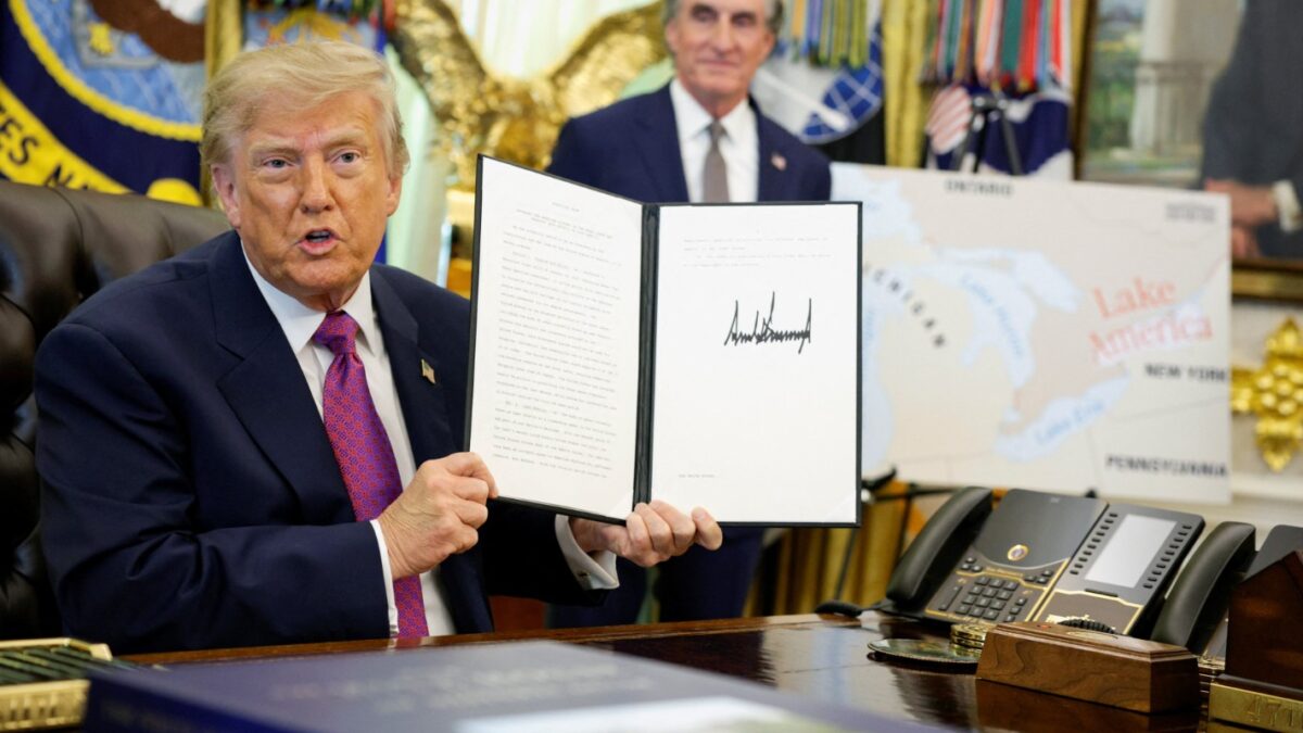 U.S. President Donald Trump holds up an executive order renaming Lake Ontario as Lake America after signing it at the Oval Office of the White House in Washington, D.C., U.S., August 27, 2026. REUTERS/Evan Vucc