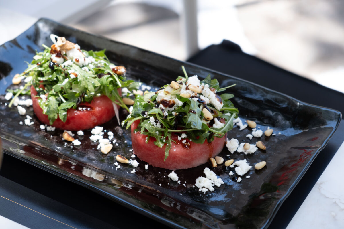 watermelon sphere with arugula grated feta cheese pine nuts onion balsamic bianco