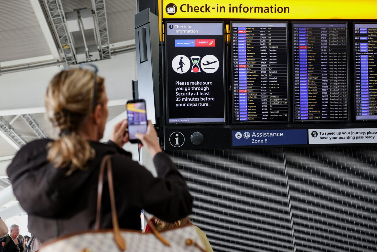 A passenger records a departure board displaying cancelled flights at Heathrow Airport's Terminal 5 in London, Britain, September 8, 2026. Some departing flights at major British airports were disrupted on Tuesday after air traffic control provider NATS experienced a technical issue, with Heathrow, Gatwick, Manchester and Stansted among the airports affected by restrictions and delays. REUTERS