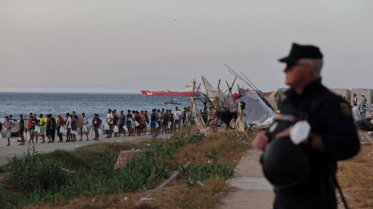 Μετανάστες σχηματίζουν ουρά για διανομή τροφίμων από τον Ερυθρό Σταυρό στην παραλία Τραμπολίν, μετά τις πρόσφατες μαζικές διελεύσεις μεταναστών από το Μαρόκο στη Θέουτα