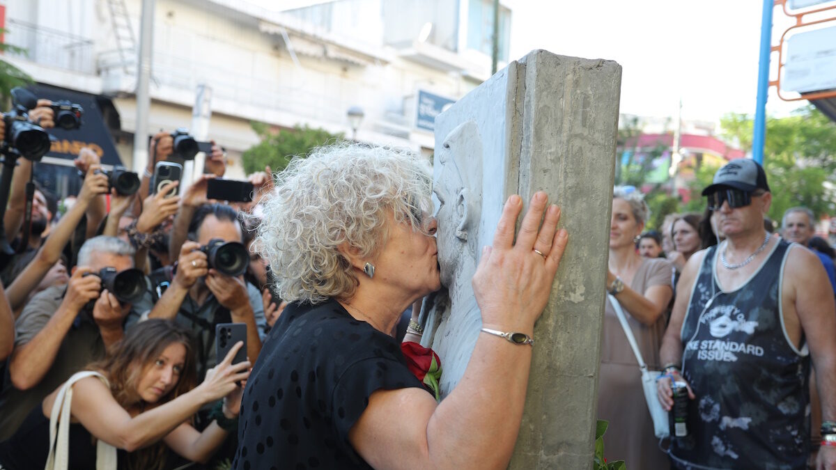 Η μητέρα του Παύλου Φύσσα, Μάγδα Φύσσα κρατώντας ένα κόκκινο τριαντάφυλλο, φιλάει το μνημείο του δολοφονημένου αντιφασίστα μουσικού στην 13η επέτειο του θανάτου του