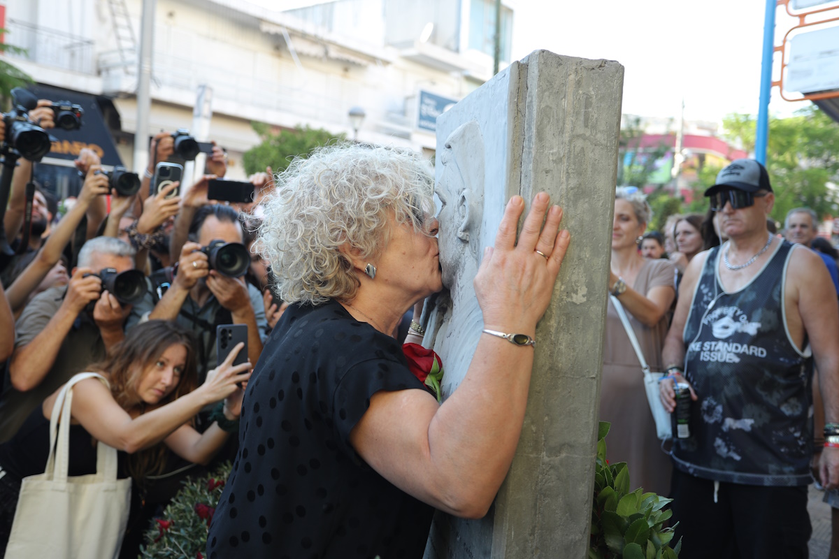 Η μητέρα του Παύλου Φύσσα, Μάγδα Φύσσα κρατώντας ένα κόκκινο τριαντάφυλλο, φιλάει το μνημείο του δολοφονημένου αντιφασίστα μουσικού στην 13η επέτειο του θανάτου του