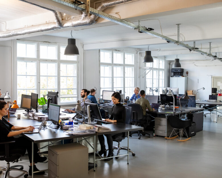 Casually dressed workers in a busy open plan office. Business people working at a modern office.