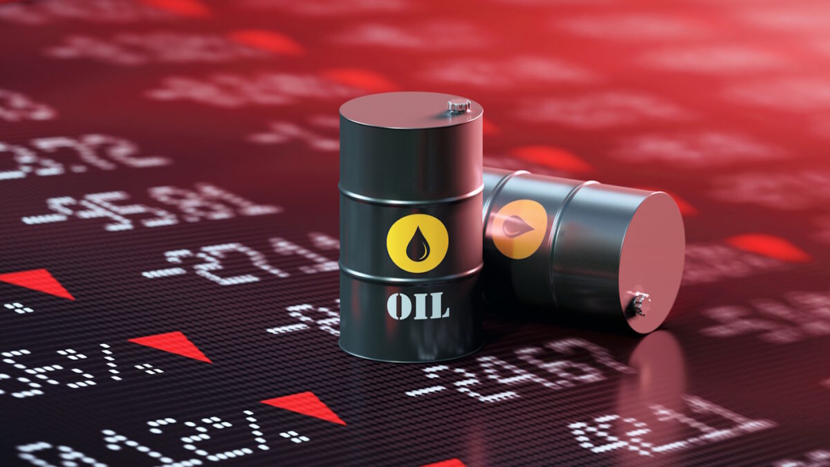 Oil drums sitting over a trading board which shows a stock market crash. Selective focus. Horizontal composition with copy space.