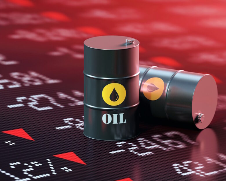 Oil drums sitting over a trading board which shows a stock market crash. Selective focus. Horizontal composition with copy space.