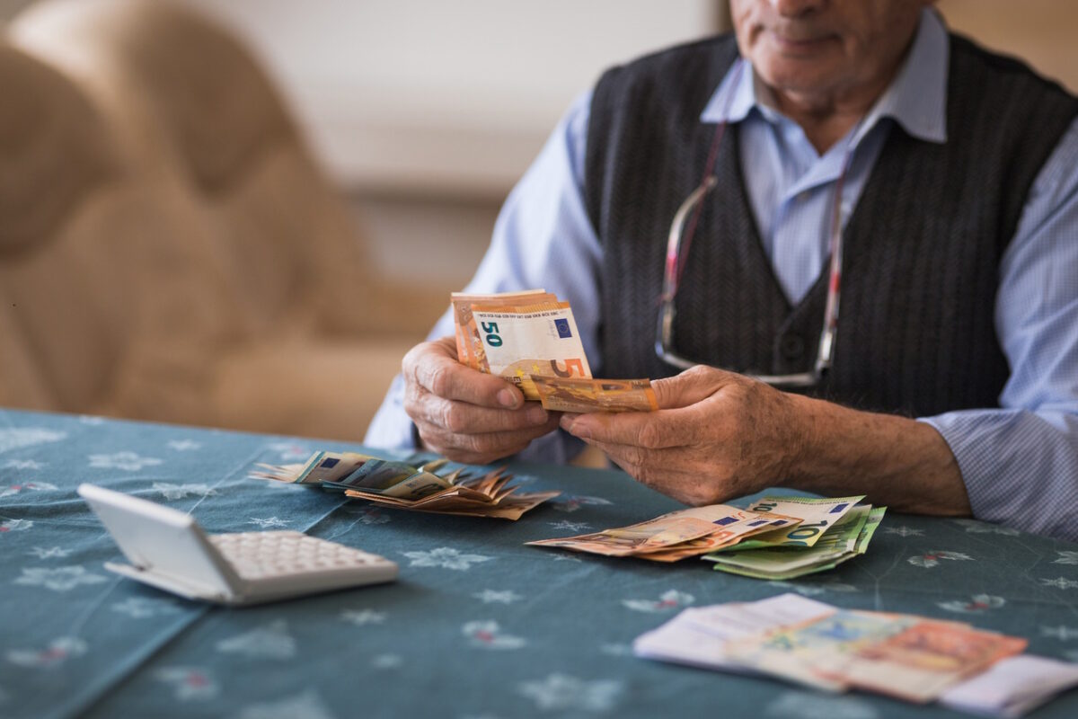 Close-up of a senior man counting money in European Union currency, syntaxiouxos metraei xrima