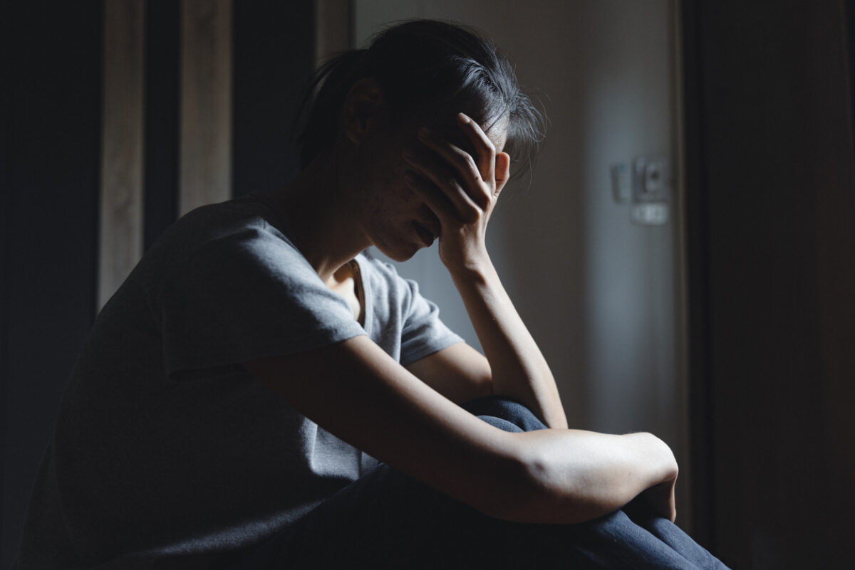 Sad woman sitting alone, woman on the bed, stress, suicidal thoughts, human trafficking