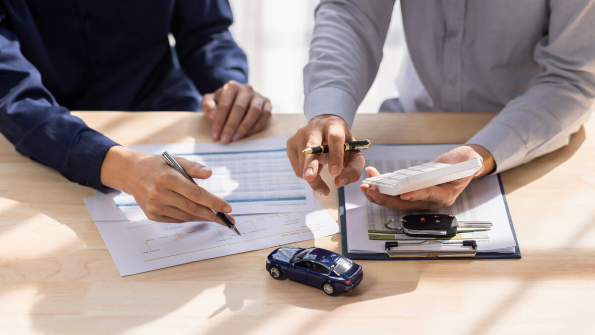 Dealer salesman giving car key to owner. client signing insurance document or rental car lease form agreement contract Insurance car concept.