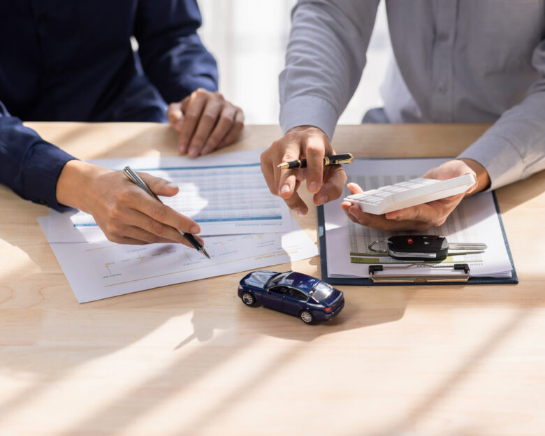 Dealer salesman giving car key to owner. client signing insurance document or rental car lease form agreement contract Insurance car concept.
