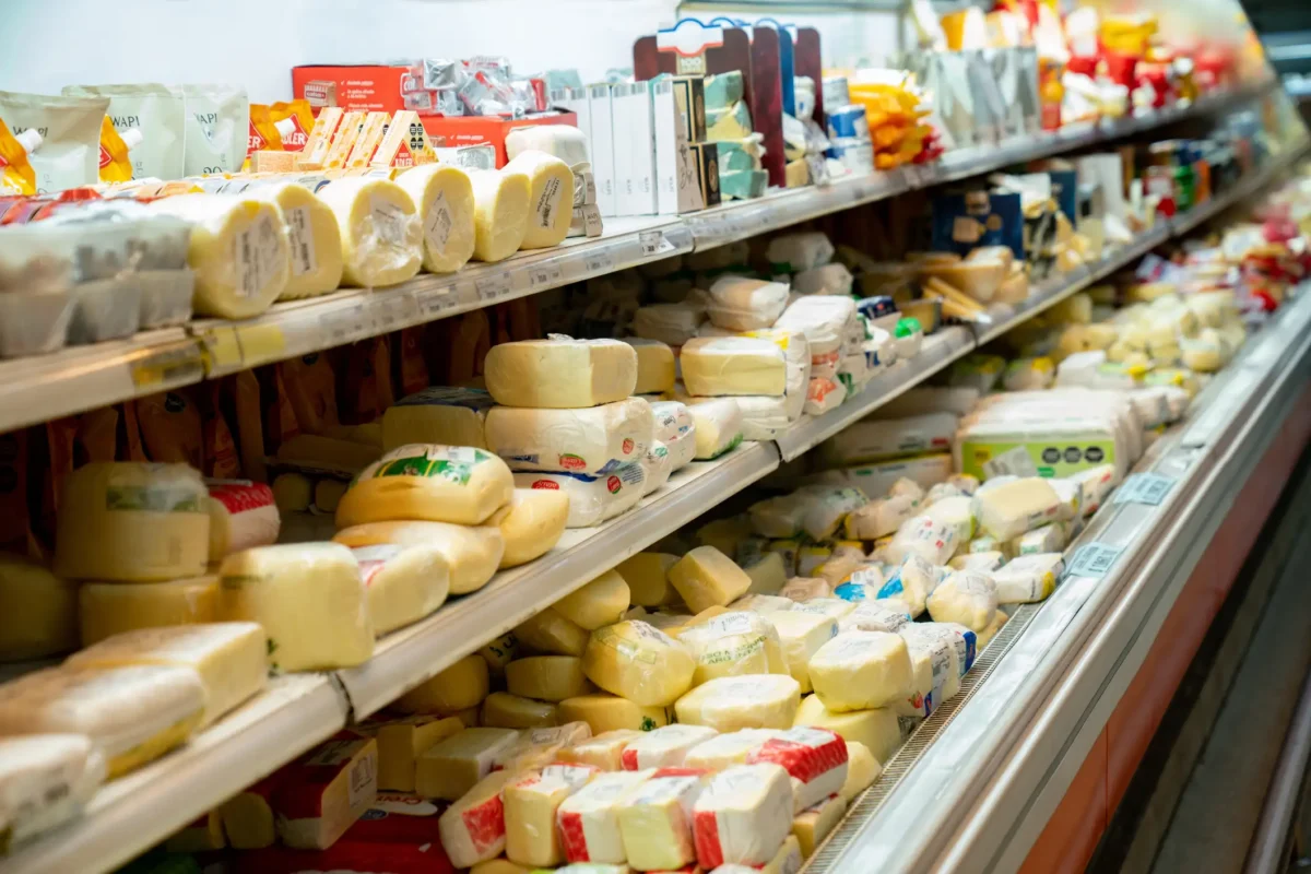 Delicious variety of cheese in the dairy aisle refrigerated section of the supermarket - No people cheese