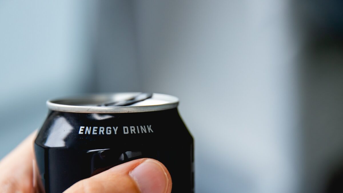 close up of a hand holding a can of energy drink